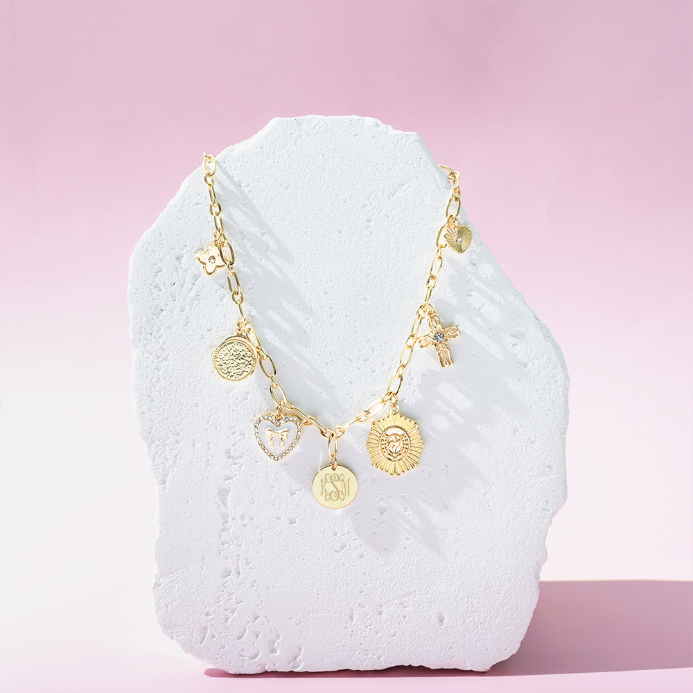white gold charm necklace on stone