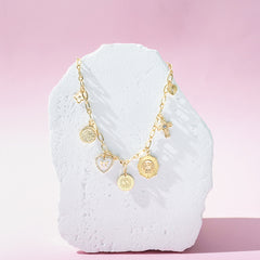 white gold charm necklace on stone