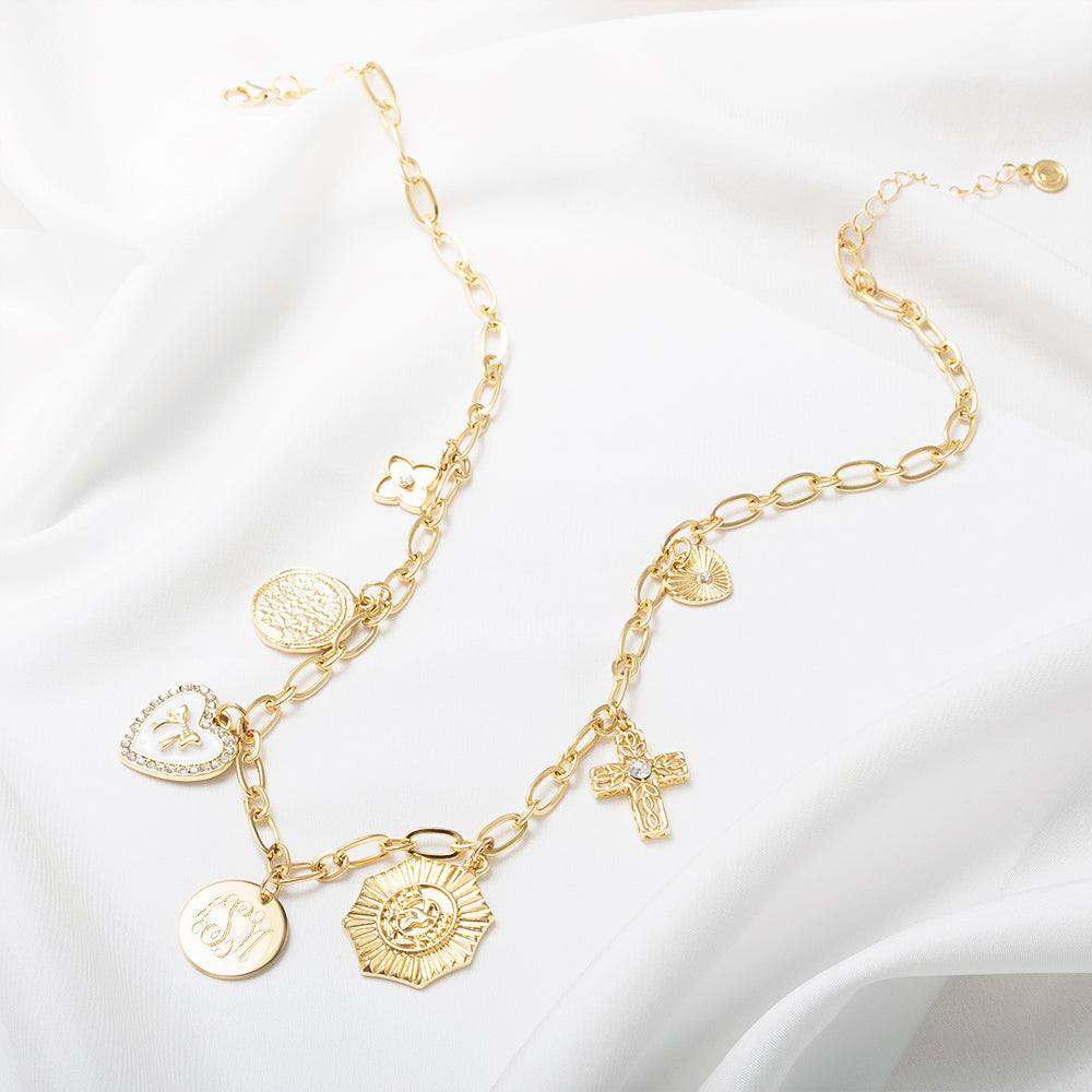 white gold charm necklace on white satin