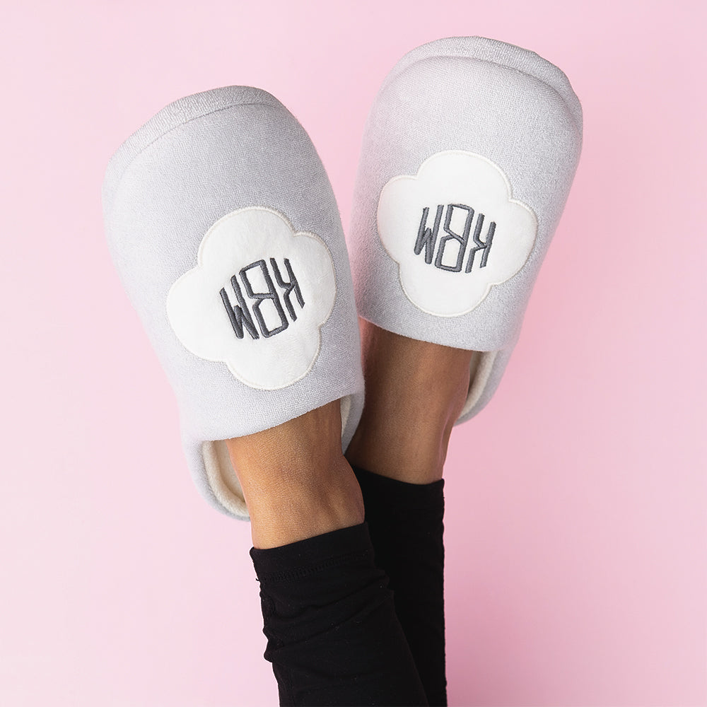 white quatrefoil slippers worn by girl on pink