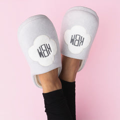 white quatrefoil slippers worn by girl on pink