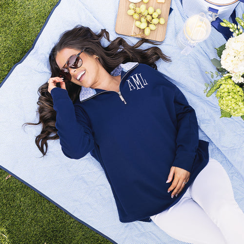 [peyton] girl wearing monogrammed quarter zip sweatshirt in navy blue shells on picnic blanket