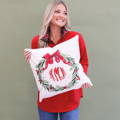 girl holding monogrammed holiday wreath pillow