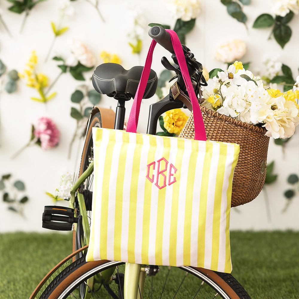 yellow stripe tote bag with pink handles on a bike