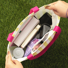 interior of striped tote bag with books, snacks, and miscellaneous items